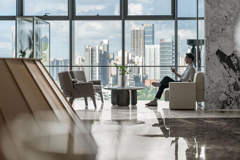 Modern interior design at Foshan Vanke Financial Centre featuring a person relaxing with city skyline views.