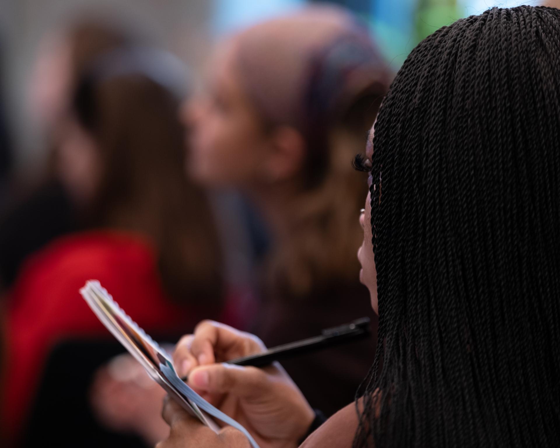 Participants engage in a workshop, taking notes on colour theory and design, highlighting creativity and nature's imperfections.
