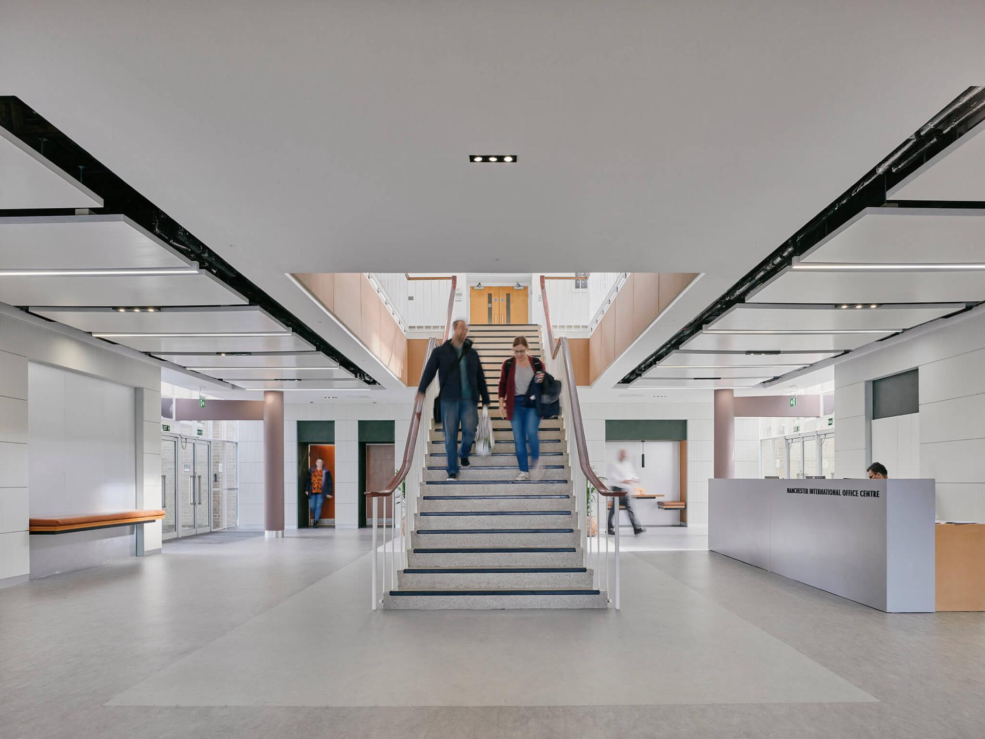 Renovated interior of Manchester International Office Centre featuring a modern staircase and welcoming reception area.