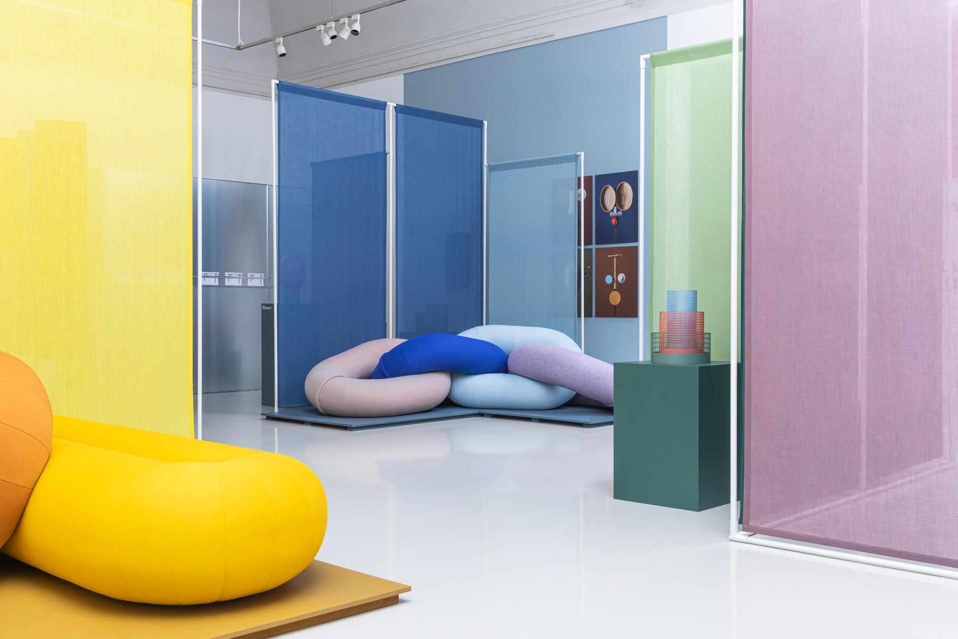 Vibrant, bio-based color palettes showcased in a contemporary design space featuring unique furniture and textile partitions.