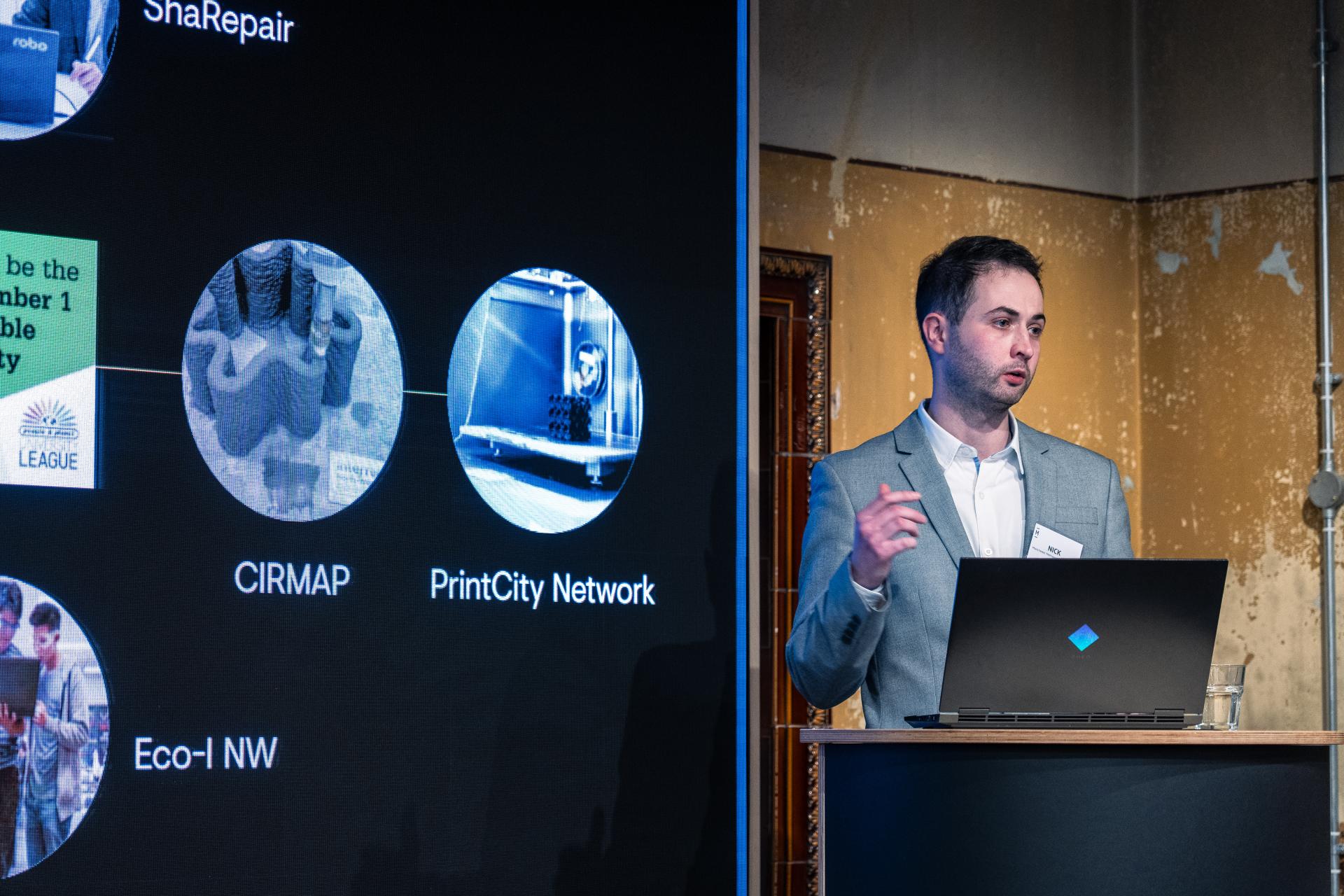 Nick Hurst presents on sustainable 3D printing innovations with Full Circle Concrete at a conference.