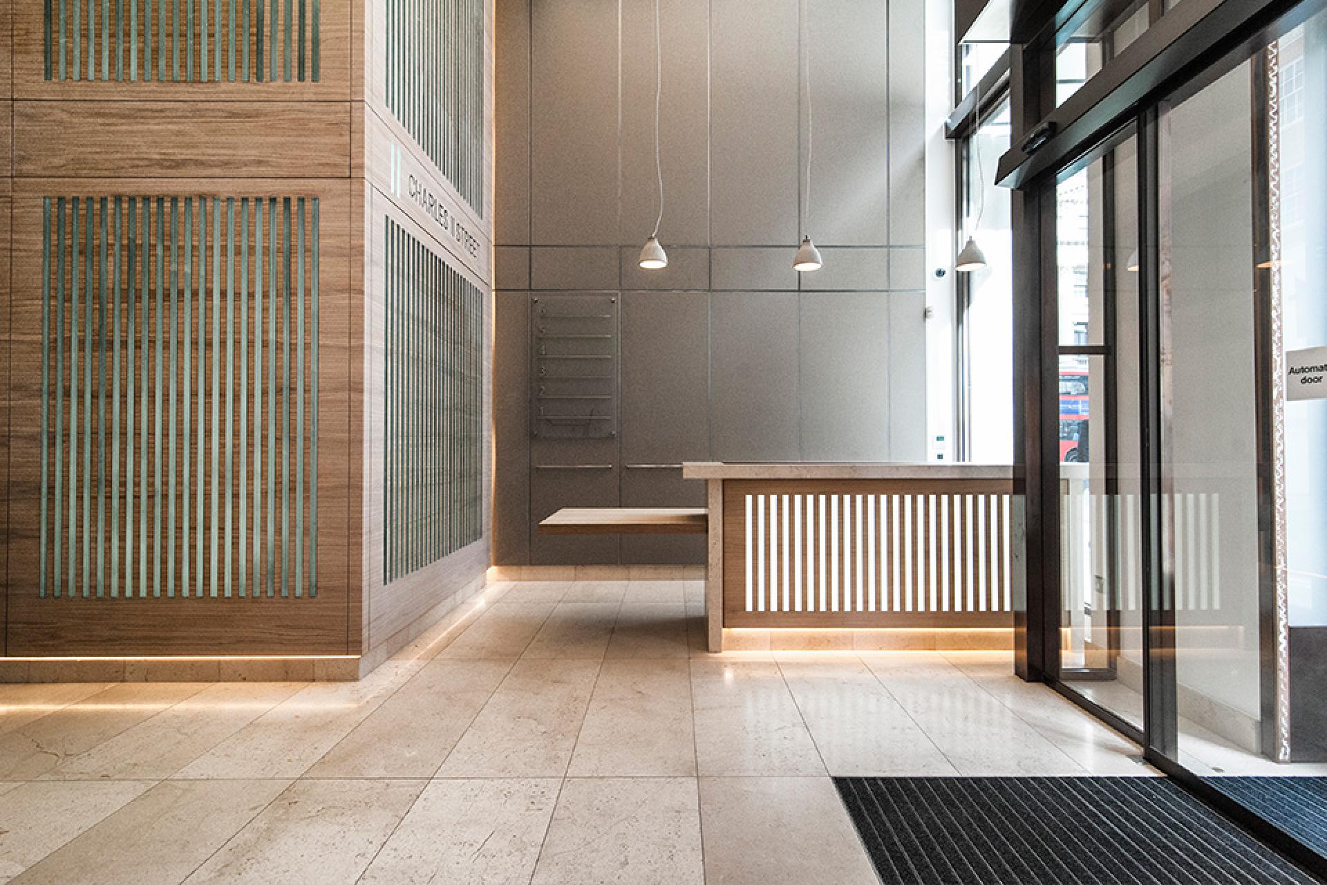Modern reception area featuring warm wood accents, striking textures, and natural light highlights, reflecting sustainable design principles.