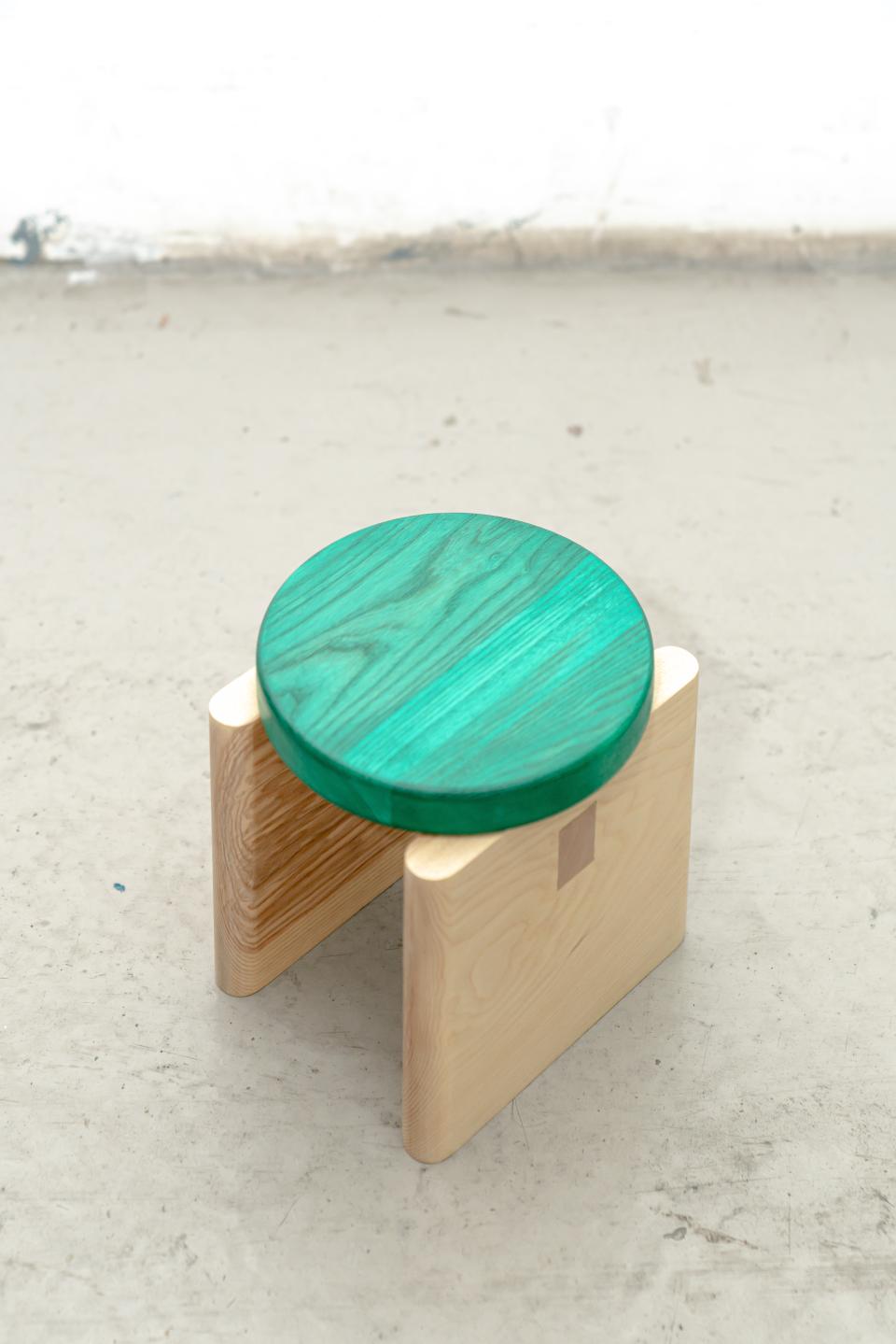 Colorful green wooden top mini-stool with natural wood legs, highlighting versatile and well-crafted furniture design.