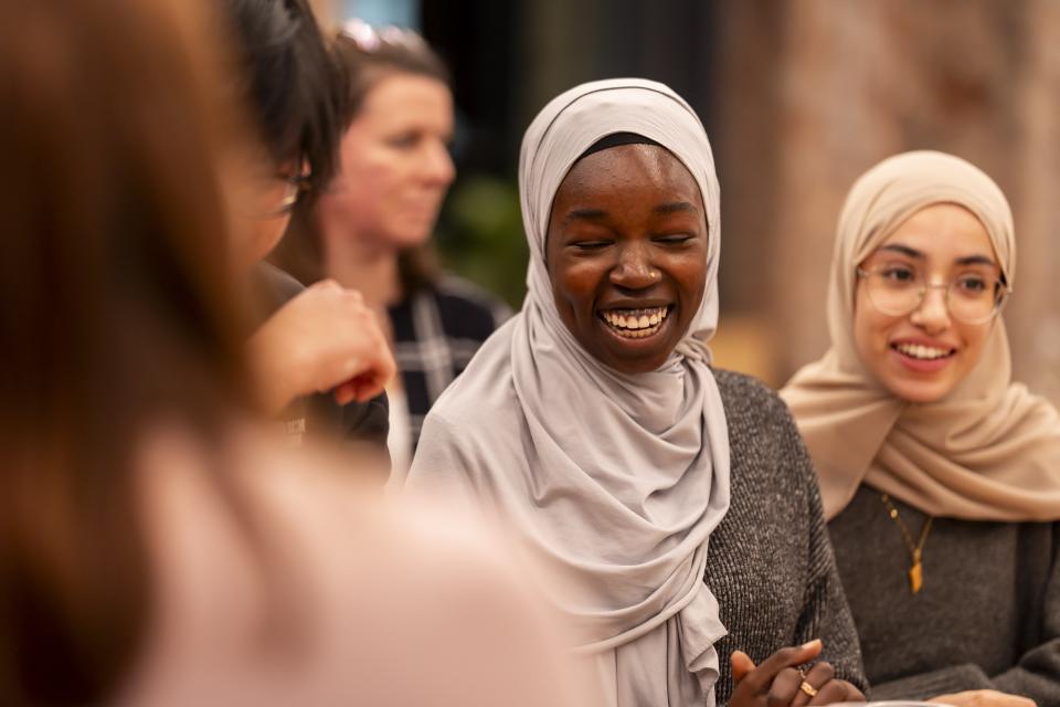 Celebratory gathering at Material Source Studio, featuring diverse creatives engaging and sharing joyful moments together.