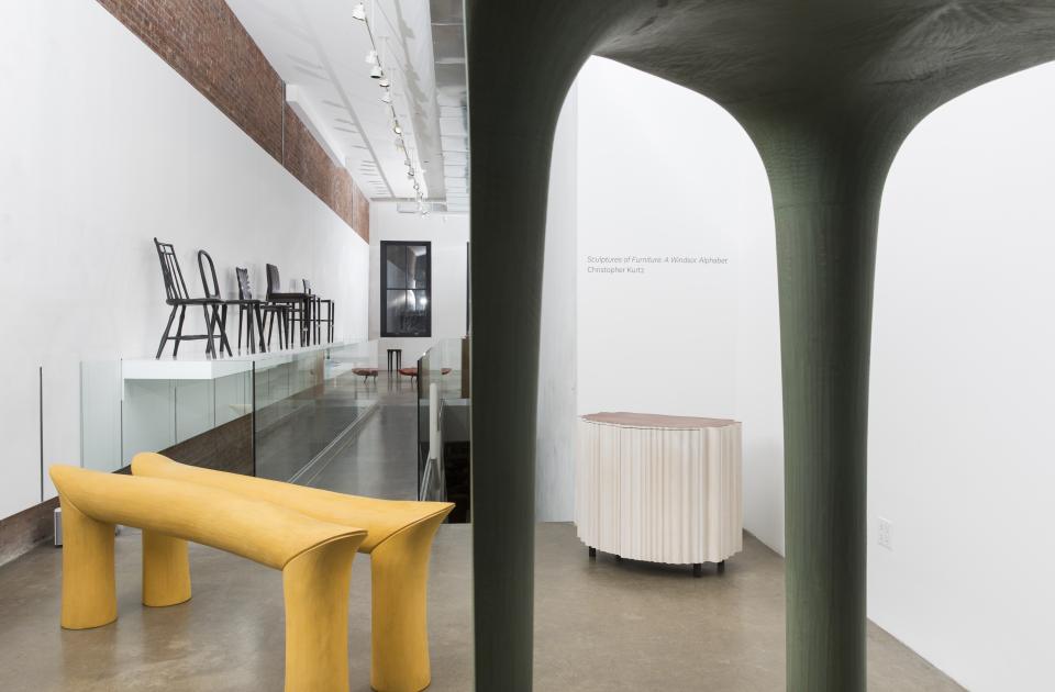 Artistic display of innovative furniture pieces by Christopher Kurtz, featuring bold yellow and green sculptural designs.