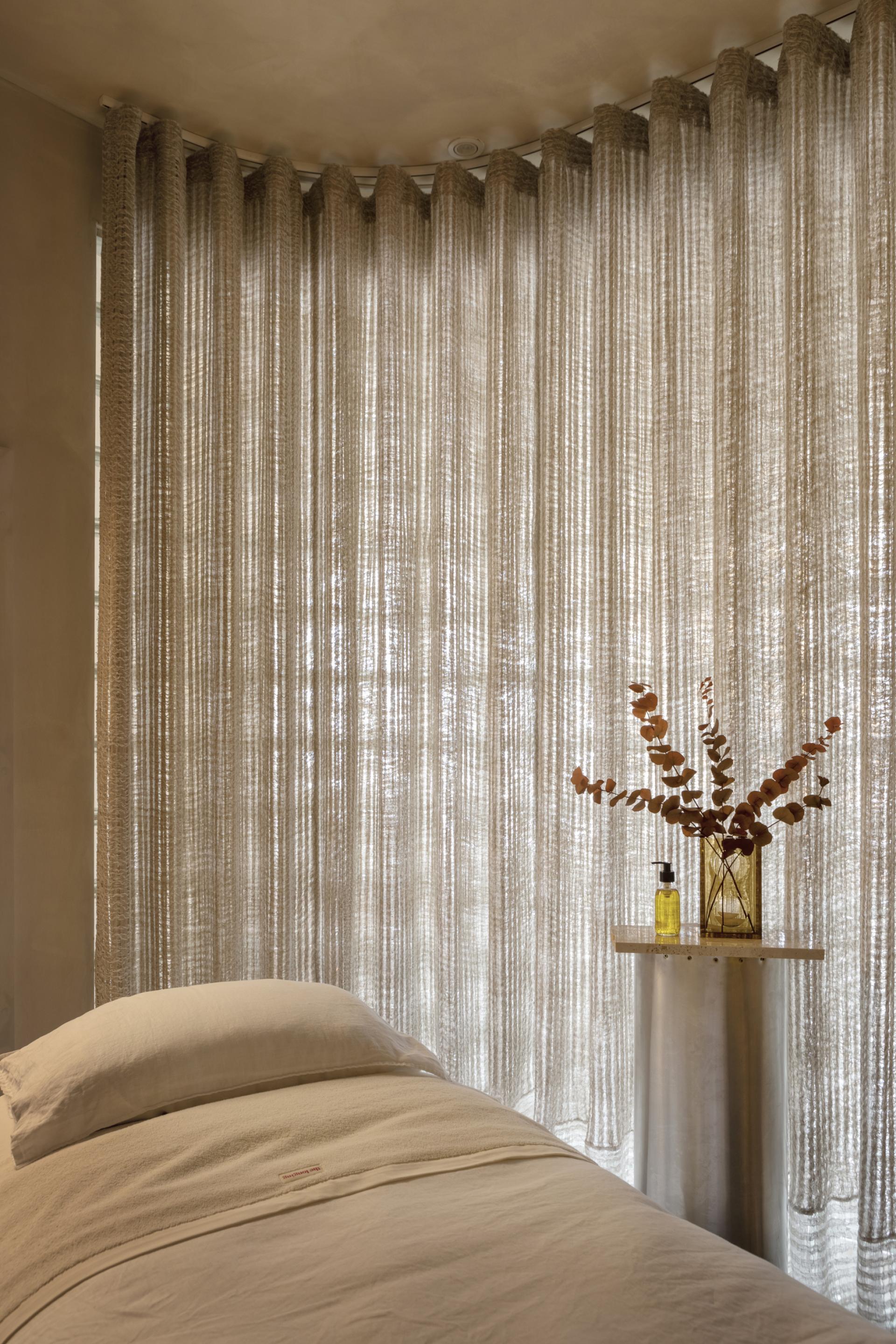 Warm, inviting interior featuring sustainable textiles, a cozy bed, and natural decor in a circular design store.