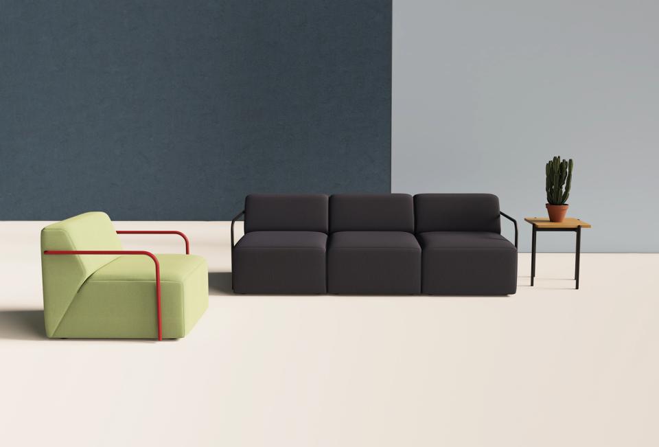 Modern furniture arrangement featuring a green chair with red accents, a dark sofa, and a potted plant.