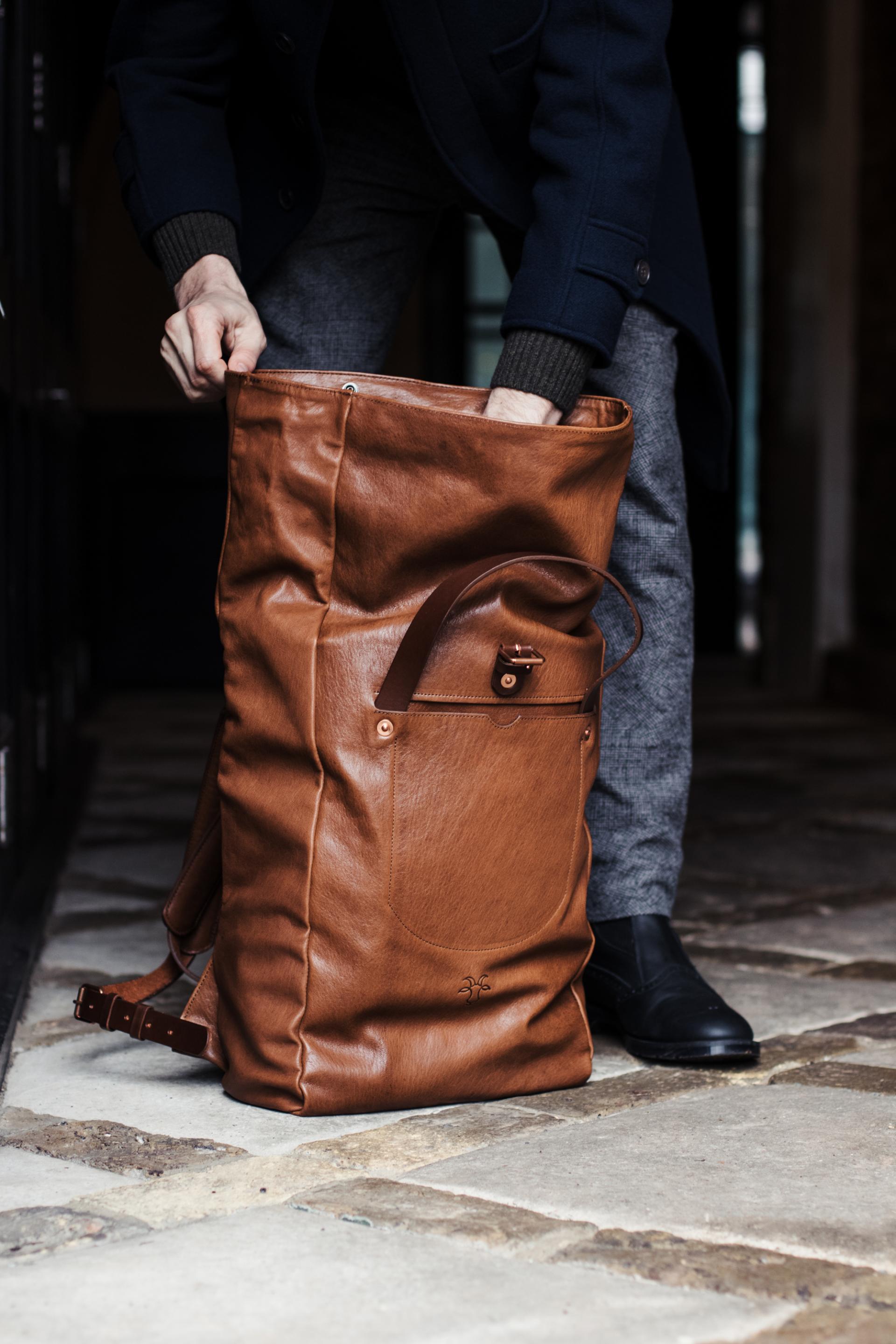 Stylish brown leather bag being packed, showcasing contemporary design at designjunction on London’s South Bank.