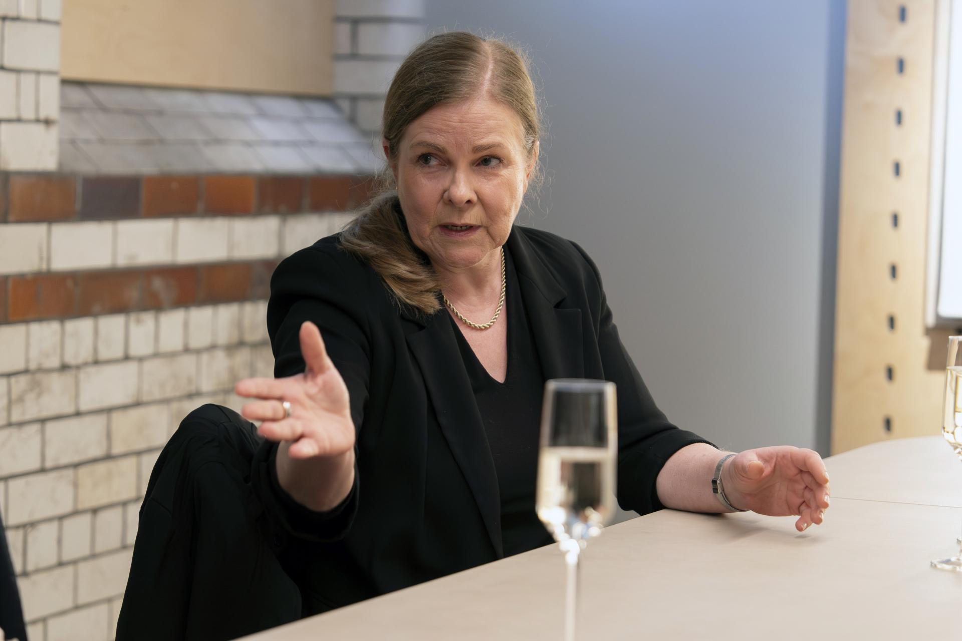 A woman speaks passionately during a roundtable discussion about Manchester's residential property landscape.