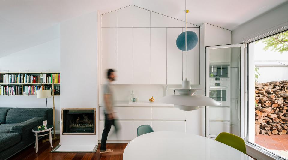 Modern attic living space featuring a sleek oversized bathtub, concealed entrance, and inviting natural light.
