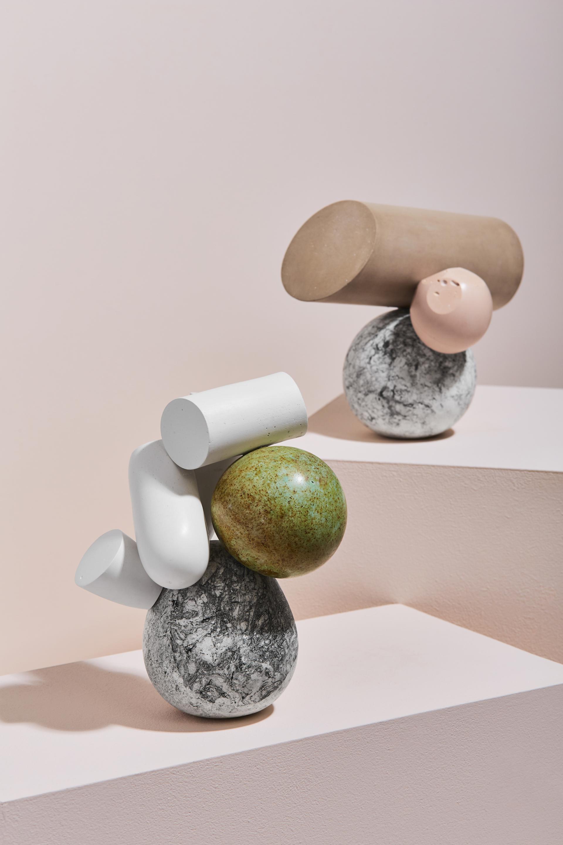 Sculptures by Vic Wright featuring geometric shapes and varied textures, displayed on minimalist pedestals in her studio.