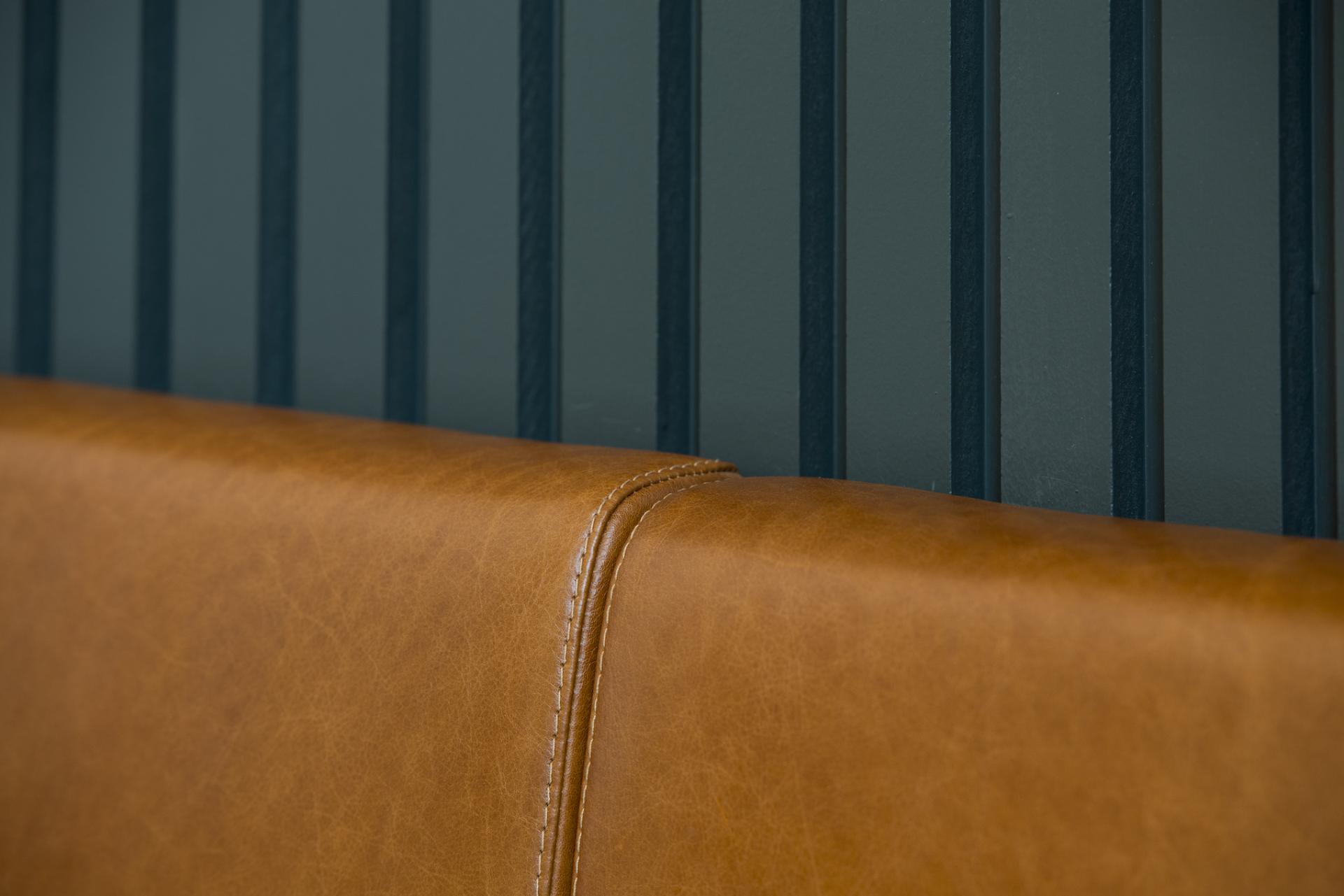 Modern leather seating against a stylish green striped wall at the new Spicer & Cole concession in Bristol.