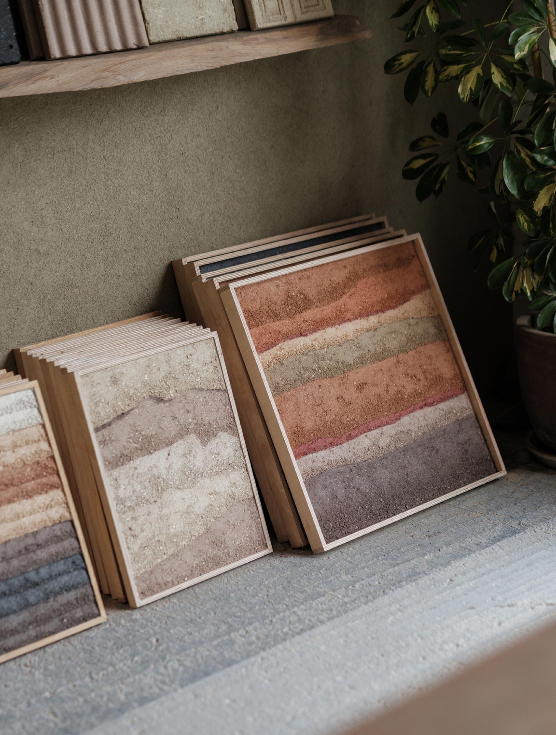 Sustainable art pieces with layered natural materials showcased on a wooden shelf, emphasizing eco-friendly design.