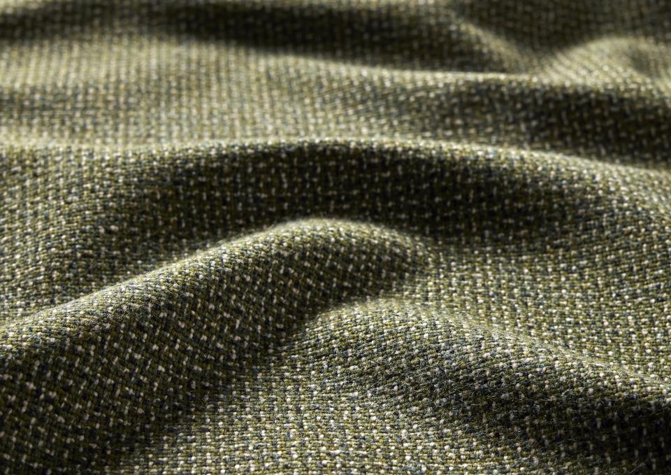 Textured green tweed fabric made from pure wool and flax, showcasing the distinct weave of Camira's Main Line Twist collection.