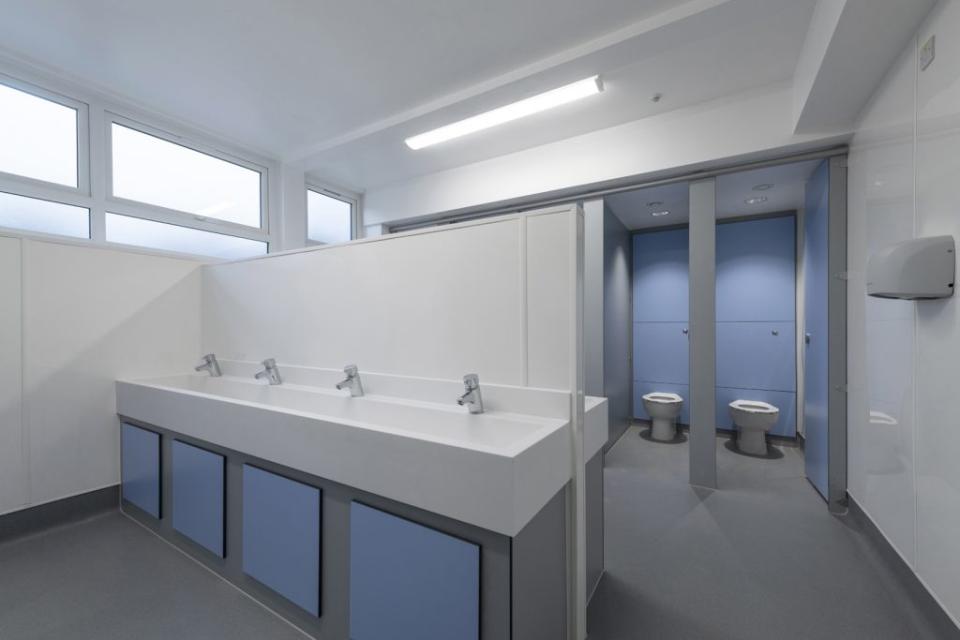 Modern boys' washroom design at Stretford Grammar featuring accessible fixtures and inclusive styling.