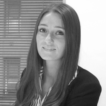 Stevie Leigh, head of interiors at Fairhursts Design Group, smiling in a professional setting with blinds in the background.