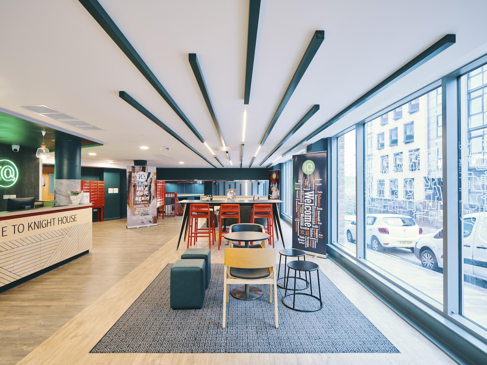 Modern interior of Knight House featuring a welcoming reception area, vibrant seating, and large windows in Sheffield.