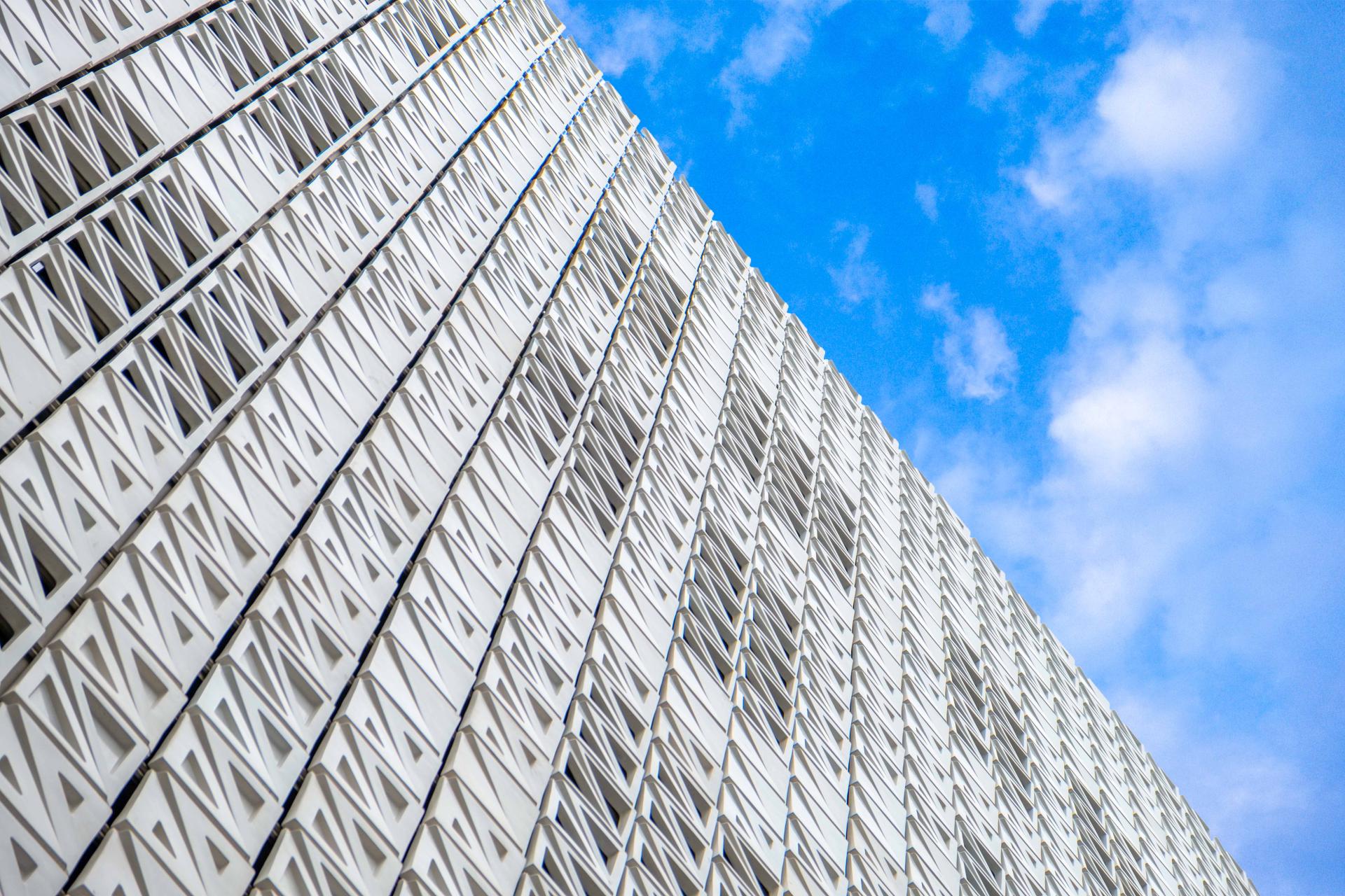 Ventilated ceramic façade of Elm House at Brighton University's business school against a blue sky.