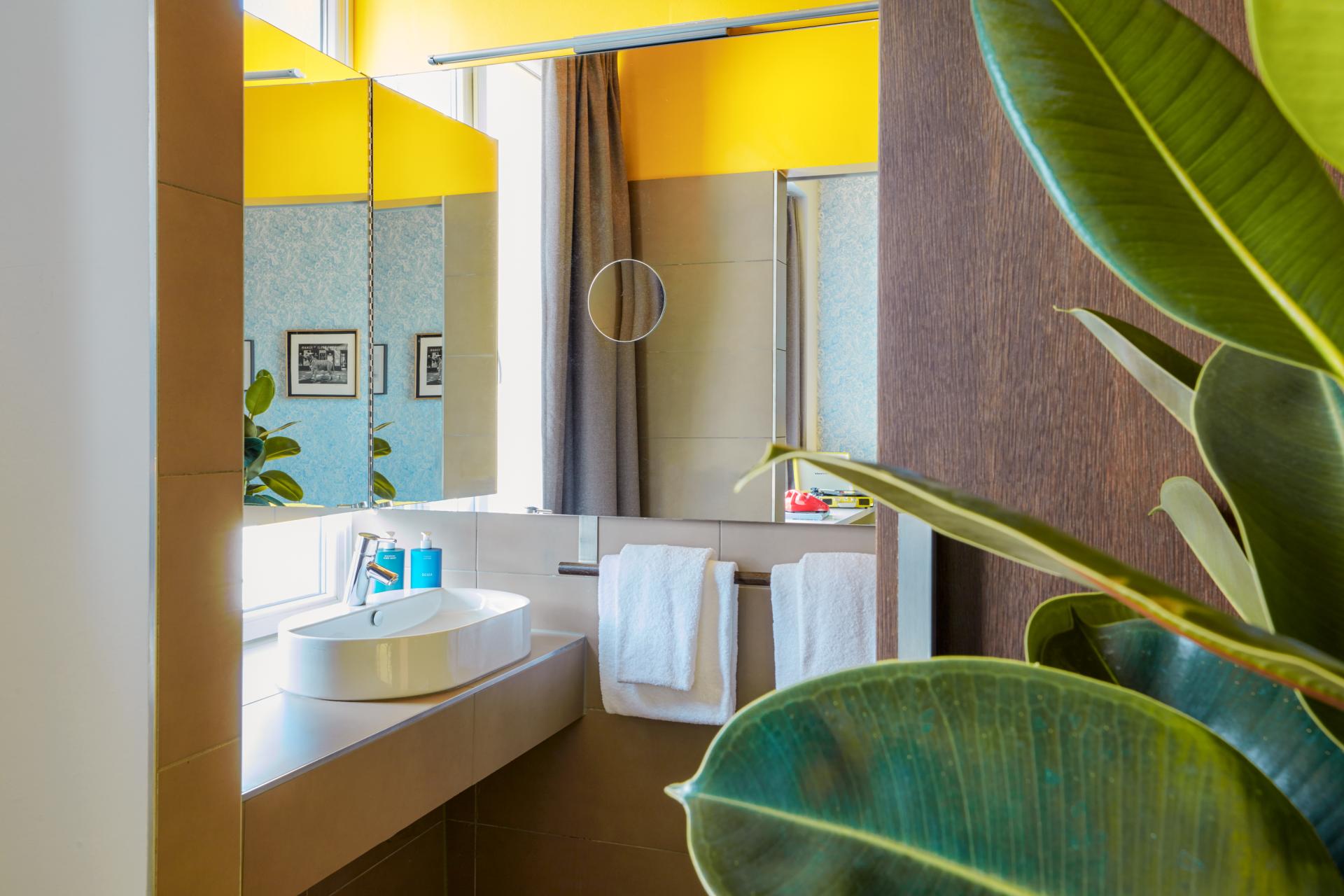 Brightly designed bathroom in Max Brown Hotel, showcasing playful colors, modern fixtures, and vibrant artwork.