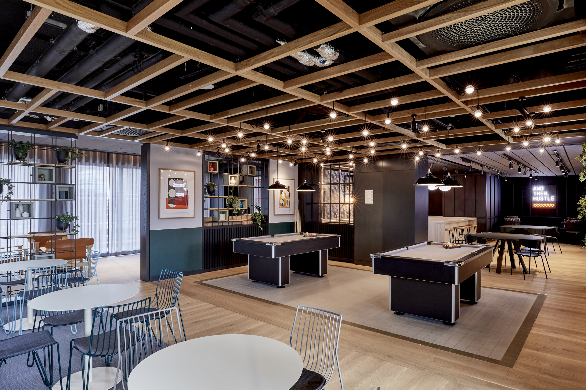 Stylish co-working space featuring pool tables, modern decor, and collaborative areas, emphasizing urban lifestyle and community interaction.