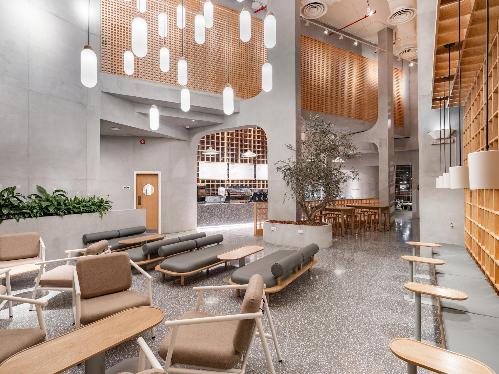 Modern coffee shop interior featuring a Japandi aesthetic with minimalist furniture, greenery, and stylish lighting design.