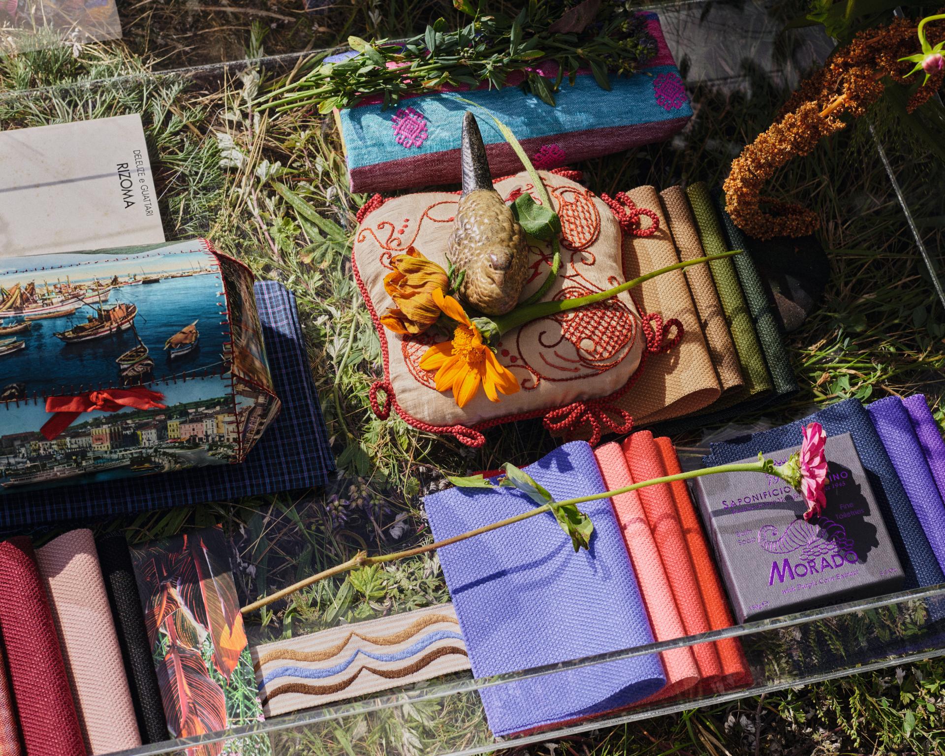 Colorful fabrics and textiles displayed with natural elements for the Workspace Design Show 2023, highlighting innovative workplace design trends.