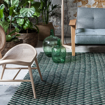Stylish interior featuring Nanimarquina's Blur collection rug, Bouroullec-designed chair, and vibrant green decor elements.