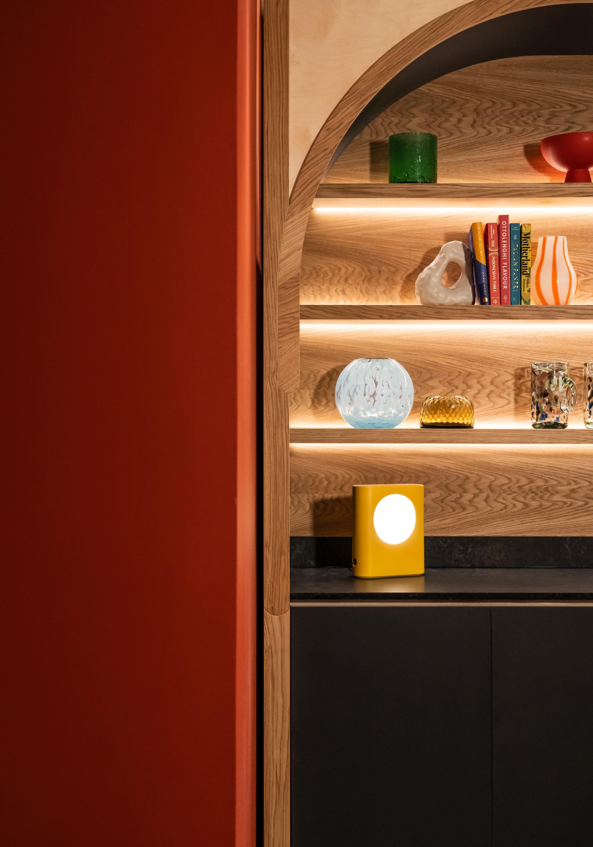 Colorful decorative items and a modern lamp on stylish wooden shelves in Material Source Studio Glasgow.