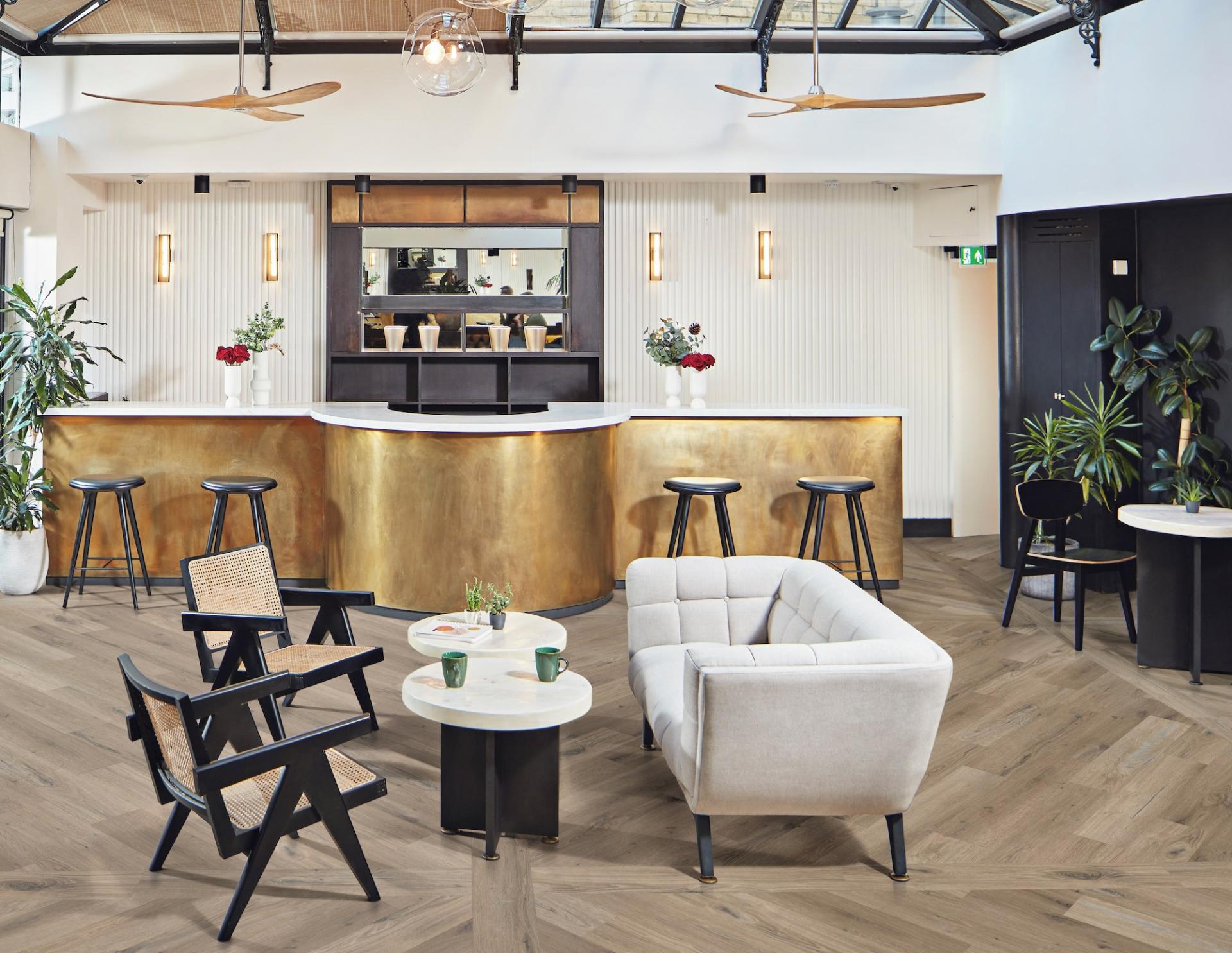 Contemporary seating area featuring Karndean Knight Tile flooring, stylish furniture, and a sleek, modern bar design.