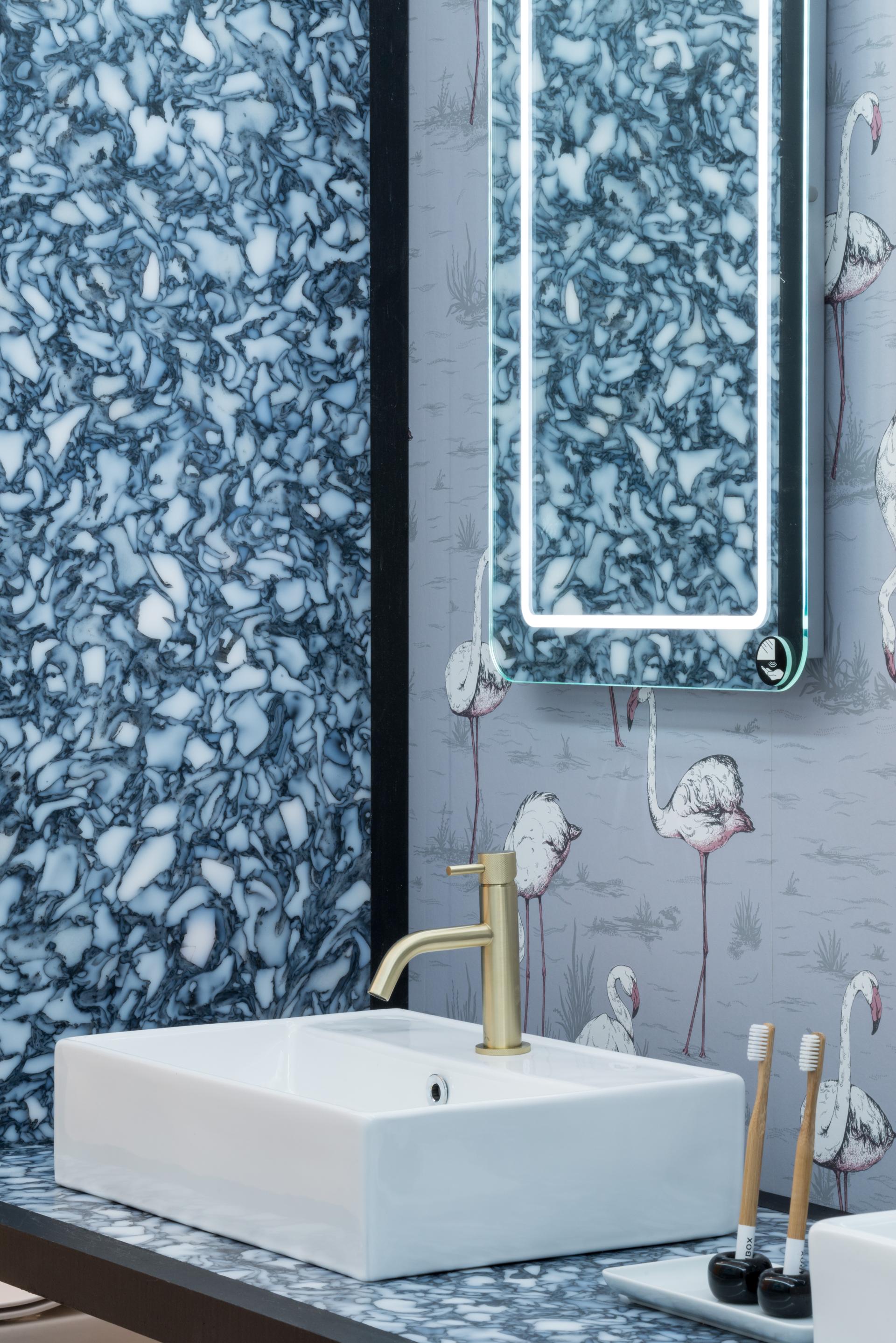 Exquisite hand-crafted bathroom panel from recycled materials, featuring a modern faucet and artistic flamingo wallpaper.