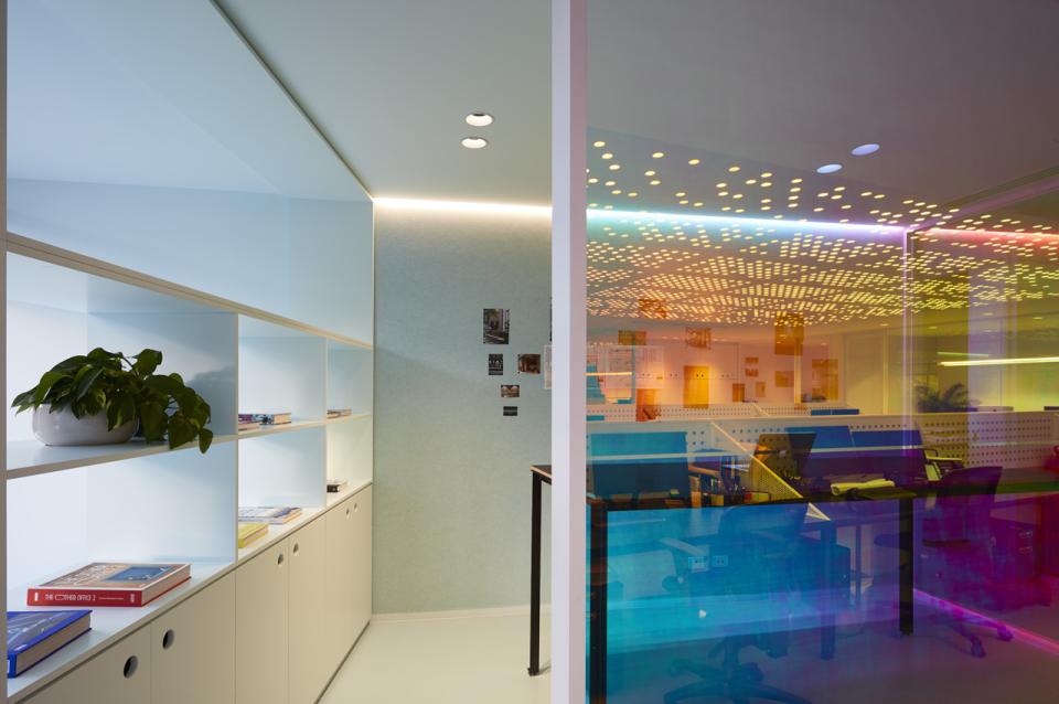 Colorful office workspace designed by Studio Y, featuring optical prisms and creative lighting effects for Ambience.