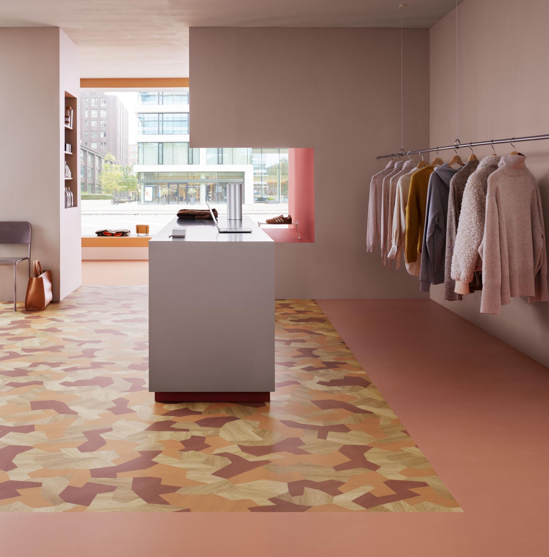 A retail setting shows clothes on a rail and Forbo flooring
