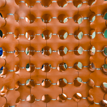 Innovative terracotta structure with circular holes, designed for natural cooling and urban temperature management by TerraCool.