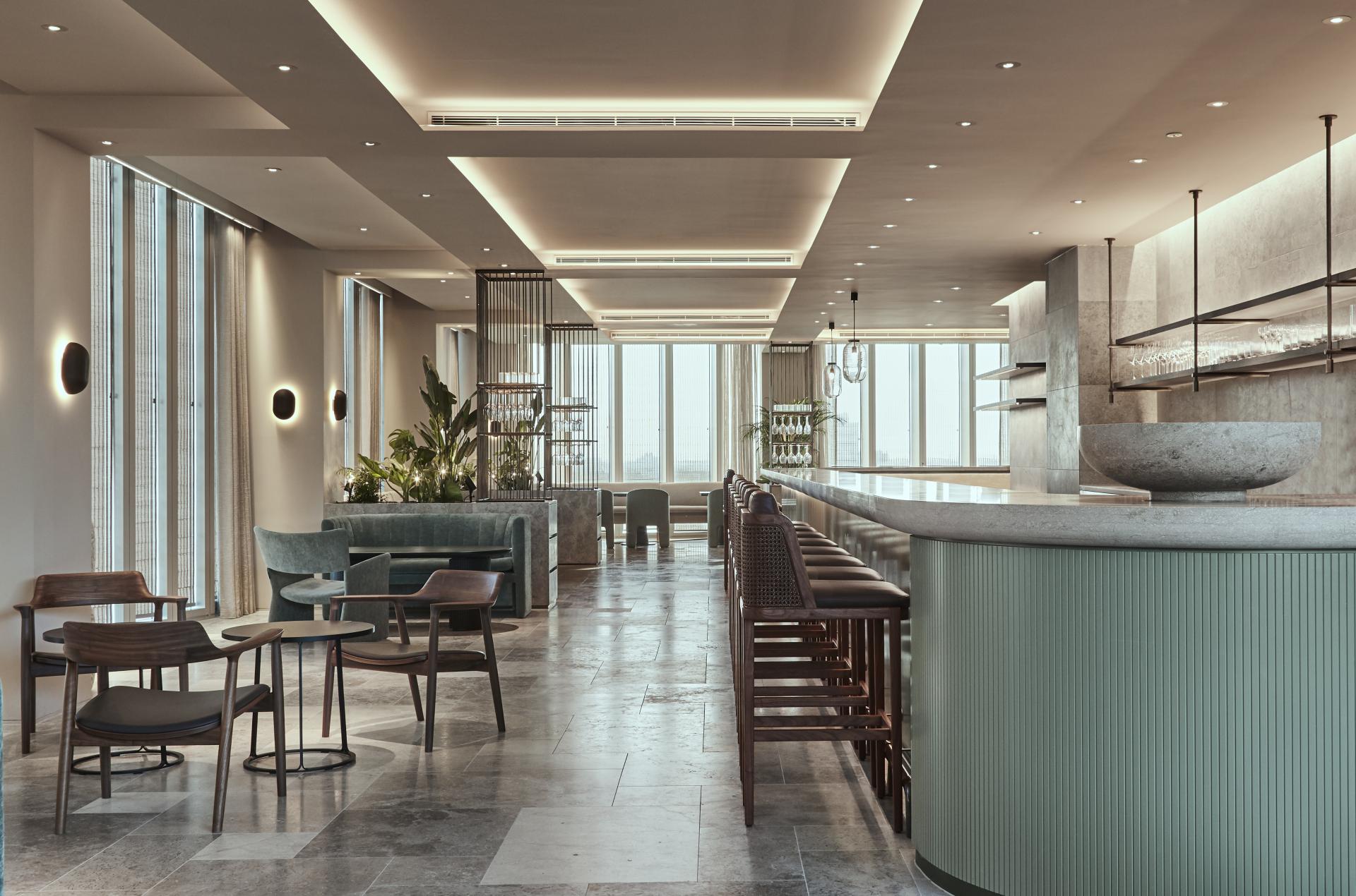 Modern bar and lounge area at The Stratford, showcasing elegant design, greenery, and luxurious hospitality.