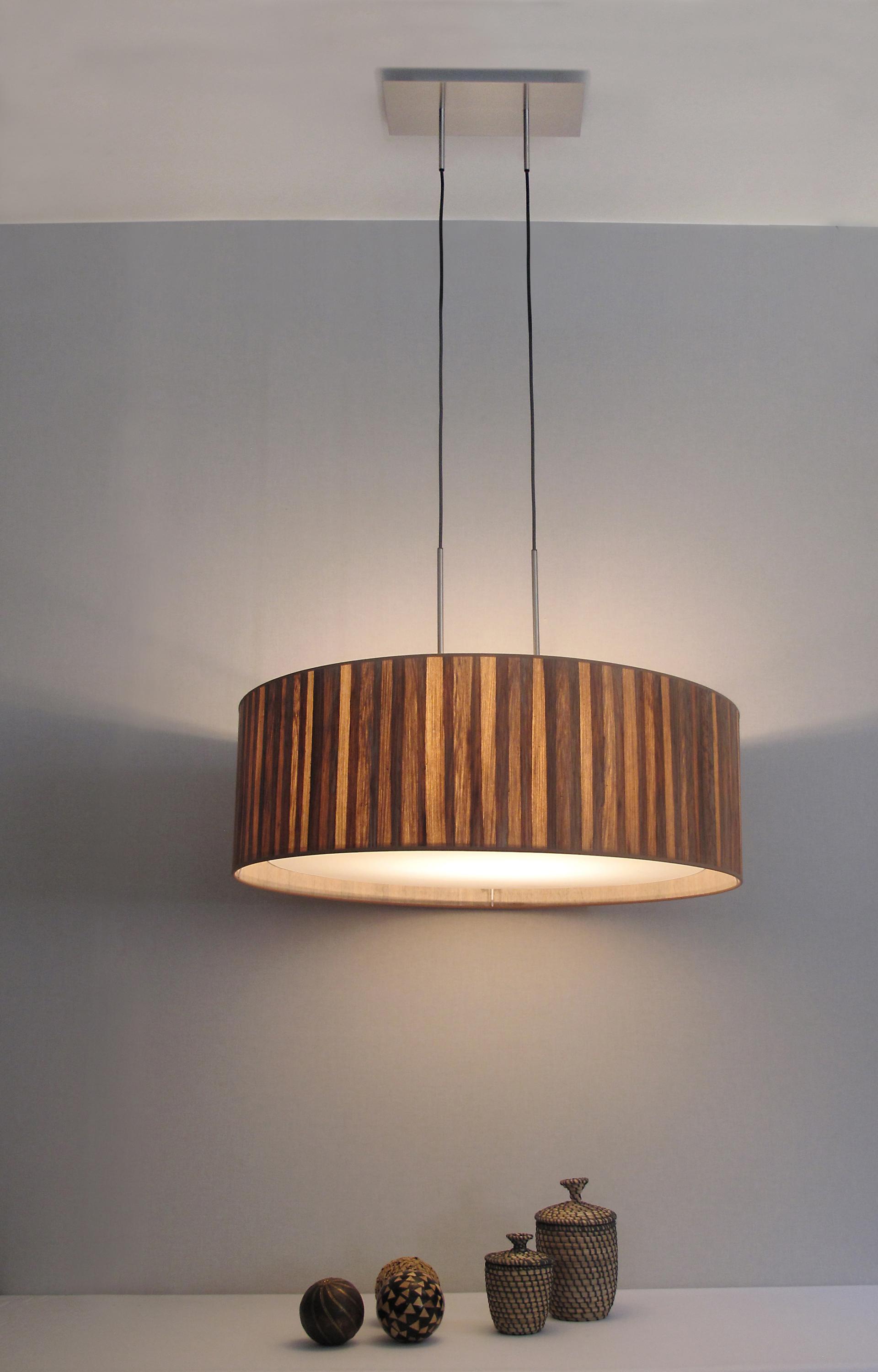 Sustainable pendant light made from banana plant trunks, showcasing eco-friendly design with textured wooden patterns and decorative vases below.