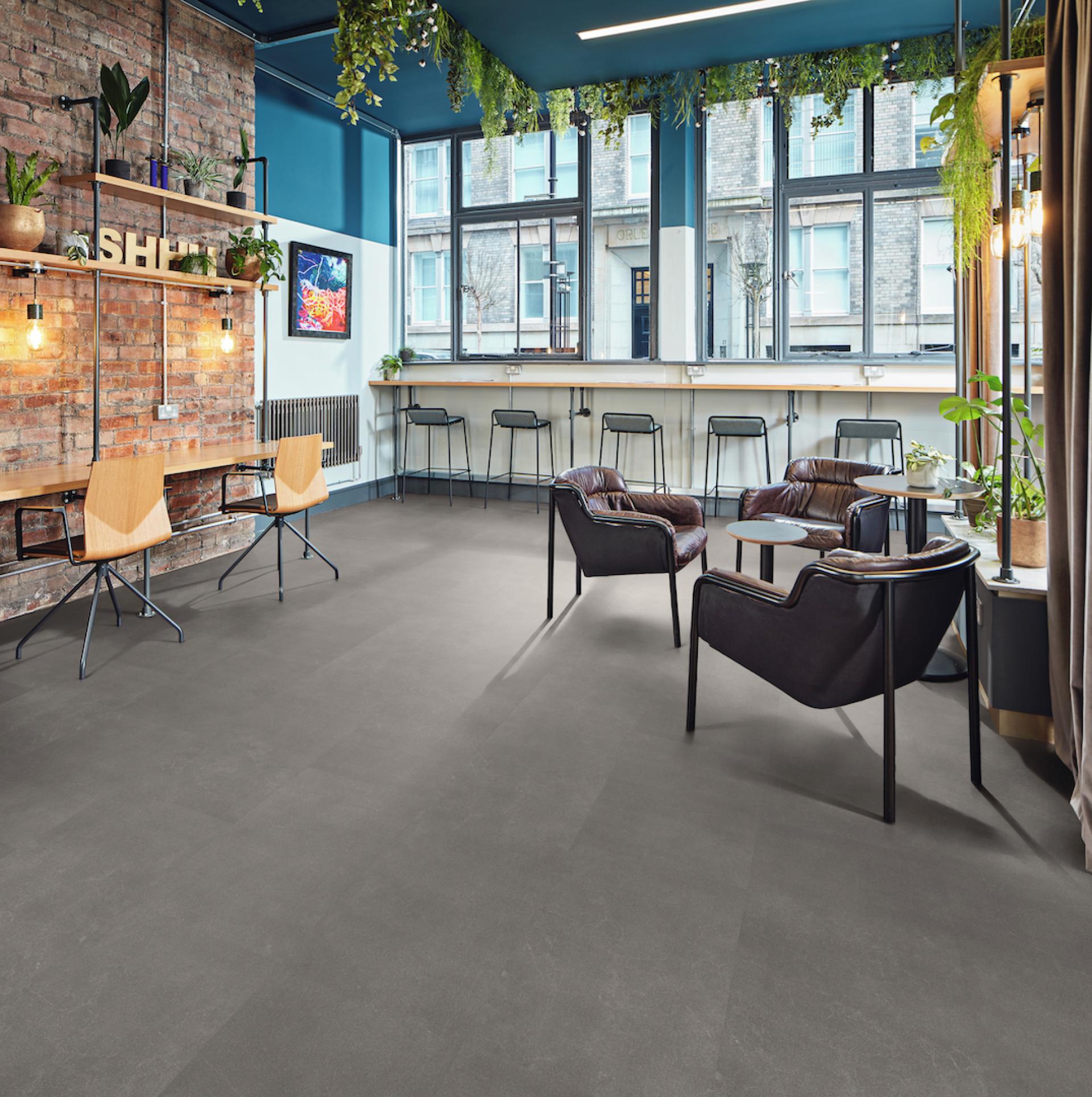 Modern café interior featuring Karndean's new limestone-inspired Korlok flooring, with stylish seating and natural lighting.