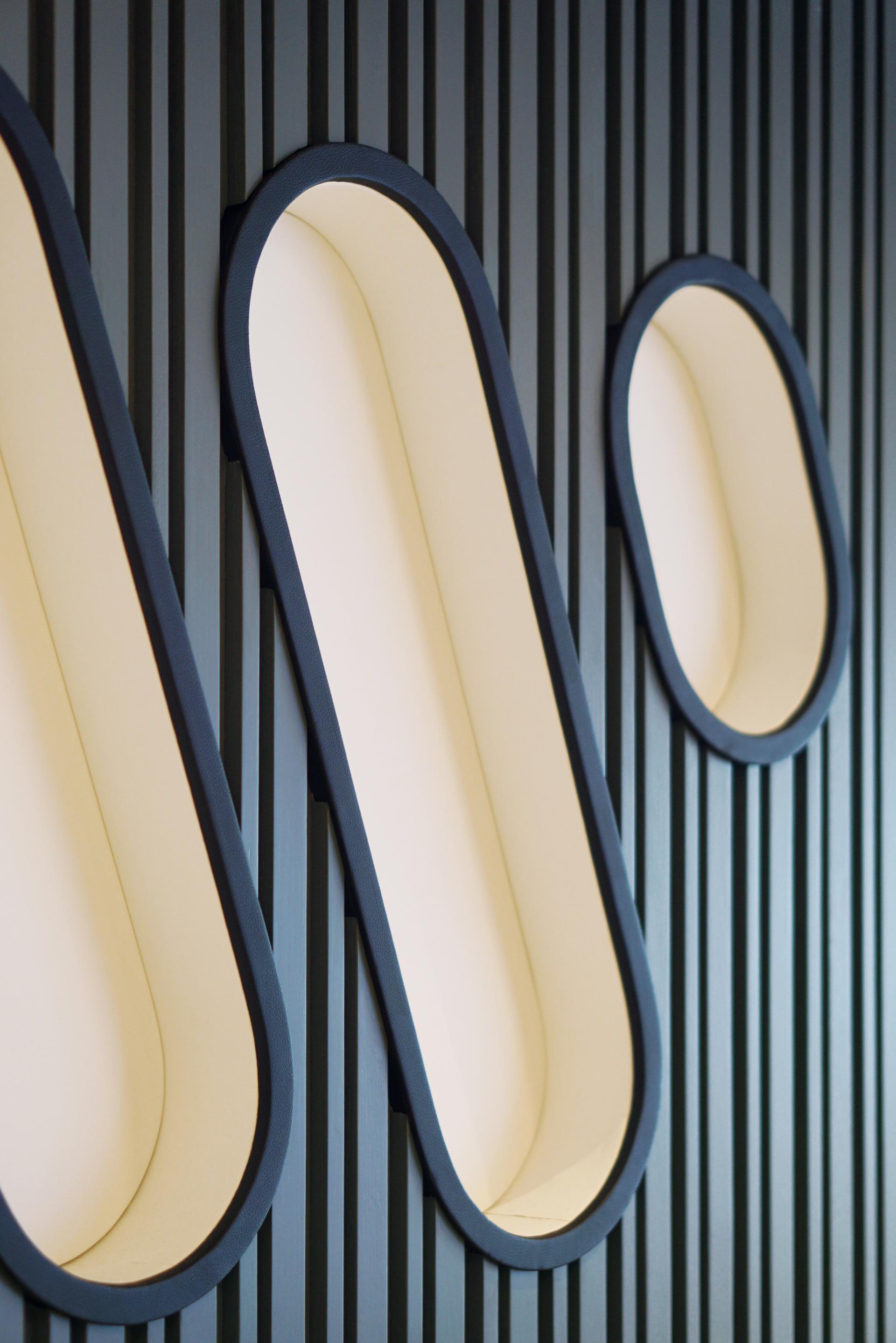 Modern wall design featuring sleek, elongated recesses, showcasing the contemporary architecture of Warner Music Hong Kong's new office.