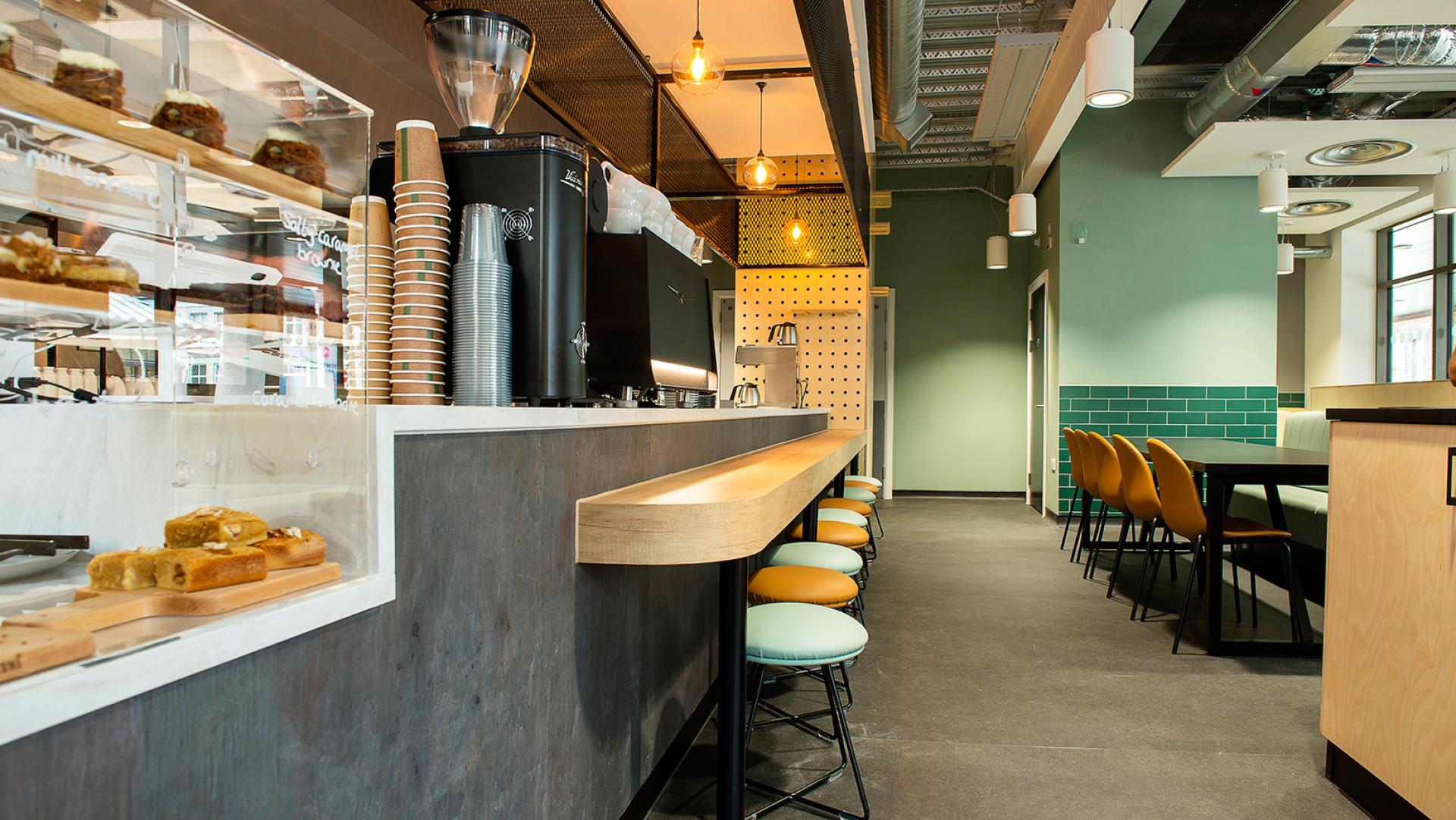 Modern café interior featuring stylish seating and a sleek counter, showcasing Standing Space's innovative design approach.