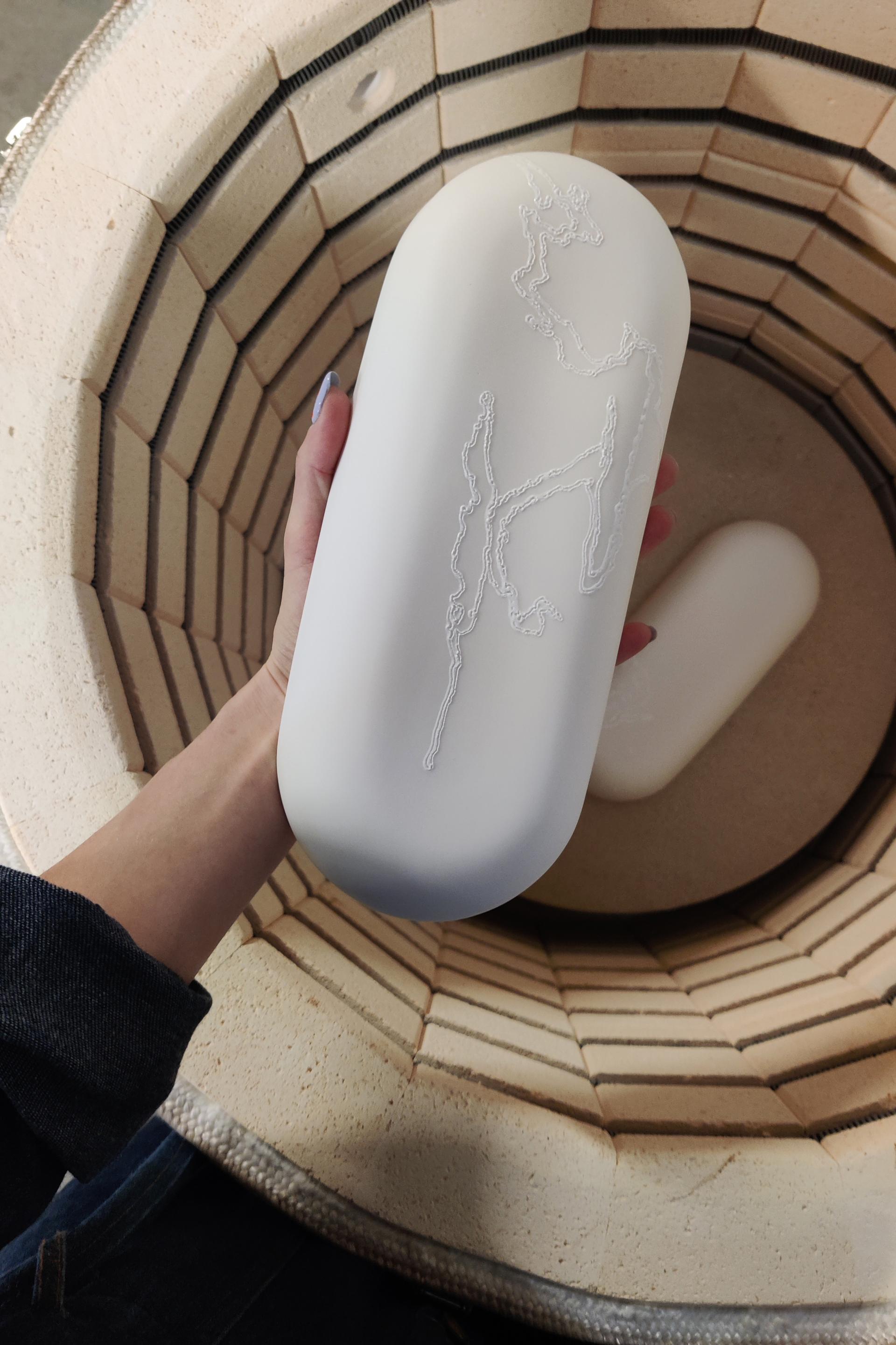 Minimalist ceramic design with intricate laser etching, showcased inside a pottery kiln at Dutch Design Week 2024.