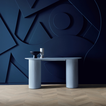 Stylish blue table with decorative items on a textured dark wall, showcasing Karndean's elegant rigid core flooring design.