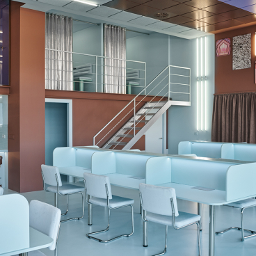 Modern coworking space in Valencia featuring colorful design, workstations, and a staircase, created by Masquespacio.