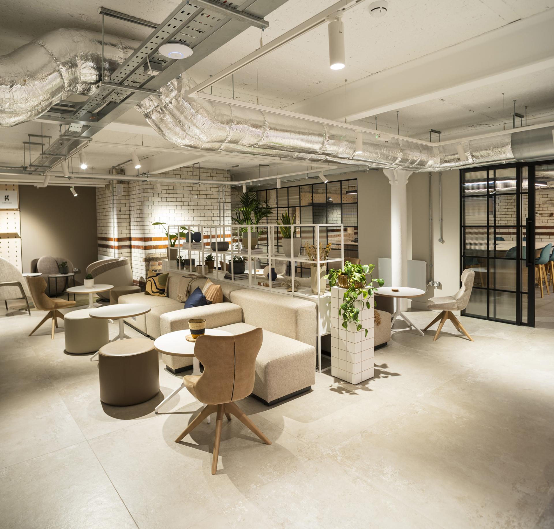 Modern interior of Material Source Studio in Manchester, featuring stylish seating, tables, and indoor plants for a creative workspace.
