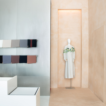 A modest women's dress displayed on a mannequin, featuring elegant colors and textures in a stylish boutique setting.