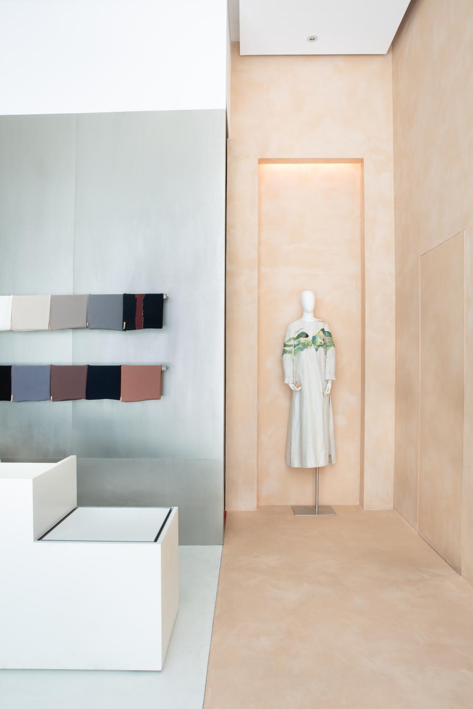 A modest women's dress displayed on a mannequin, featuring elegant colors and textures in a stylish boutique setting.