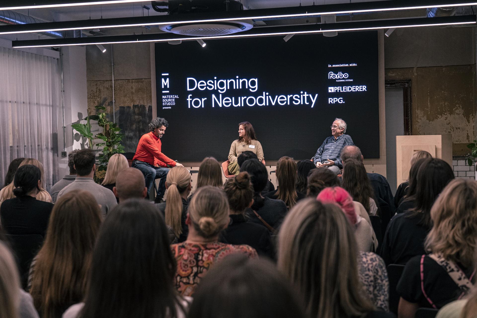 Panel discussion on neurodiversity at Material Source Studio, featuring speakers and an engaging audience.