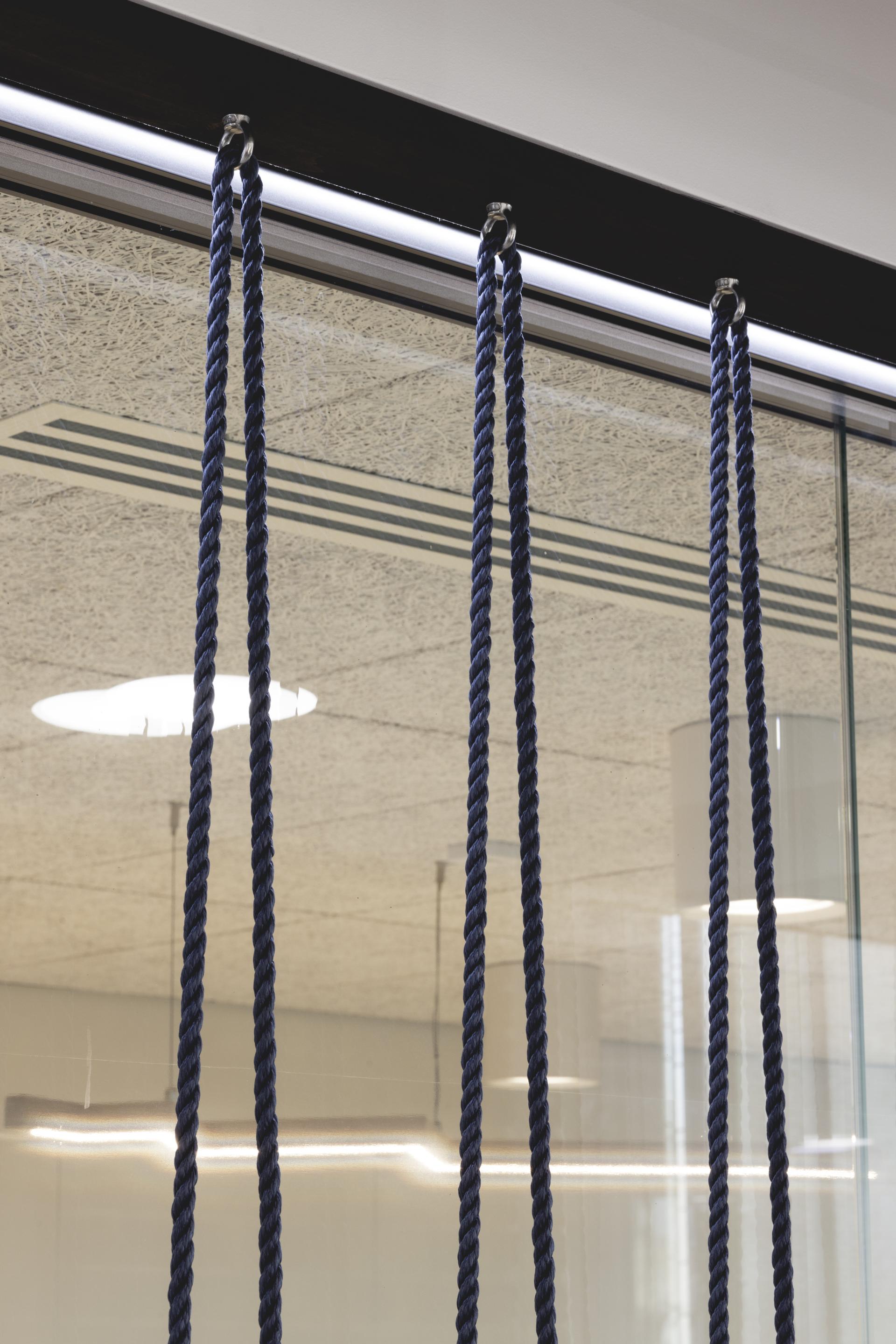 Rope details hang from glass partitions, highlighting the innovative design approach in PRS for Music's London HQ by Ekho Studio.