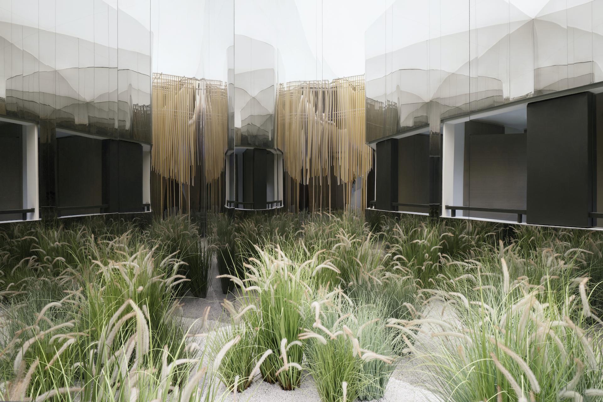 Floral-inspired architectural design featuring sweeping curves, reflective surfaces, and lush greenery at The Florescence, Guangzhou.