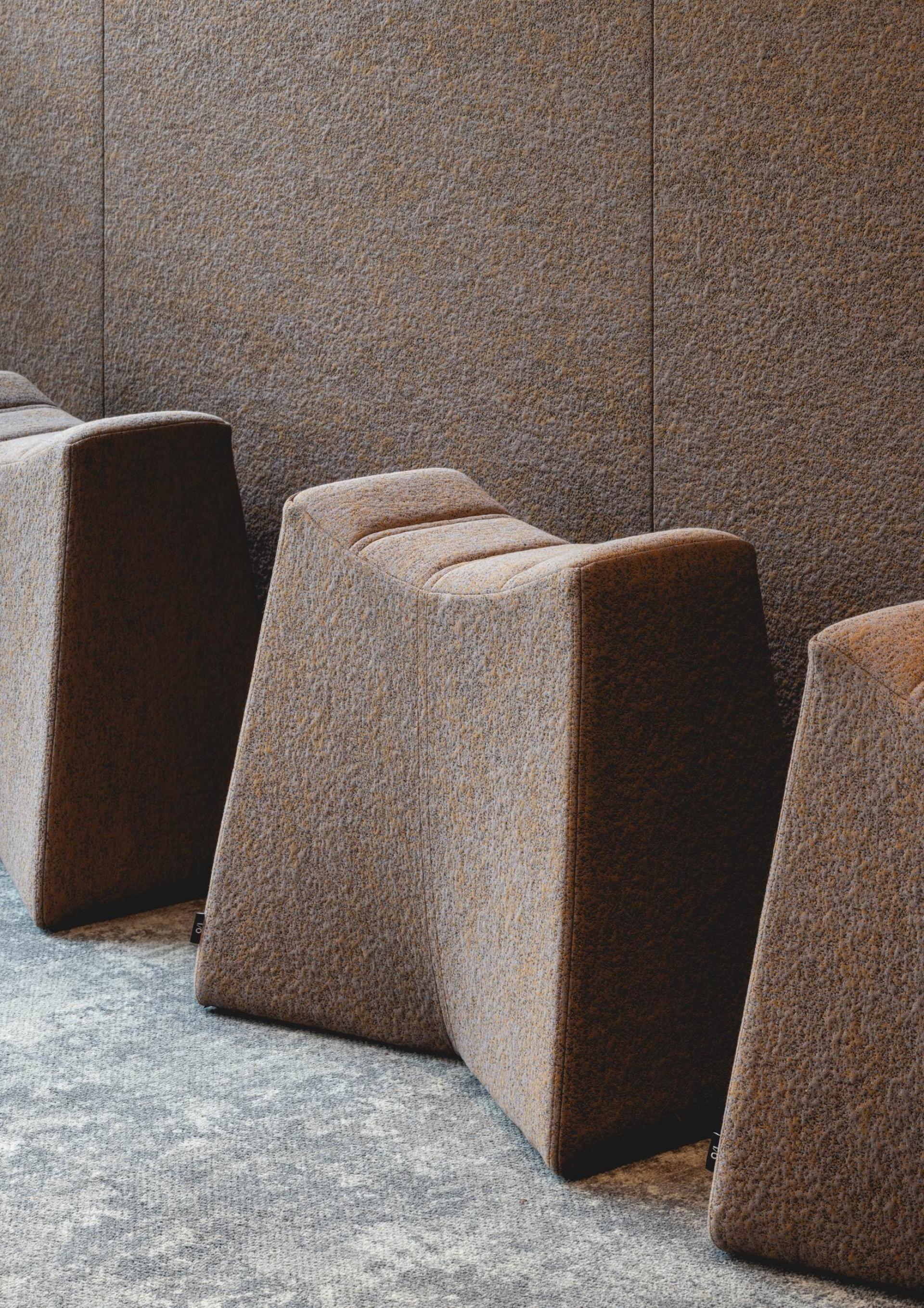 Curved, textured seating elements in a modern workplace showcase Art Deco-inspired design and create a calming atmosphere.
