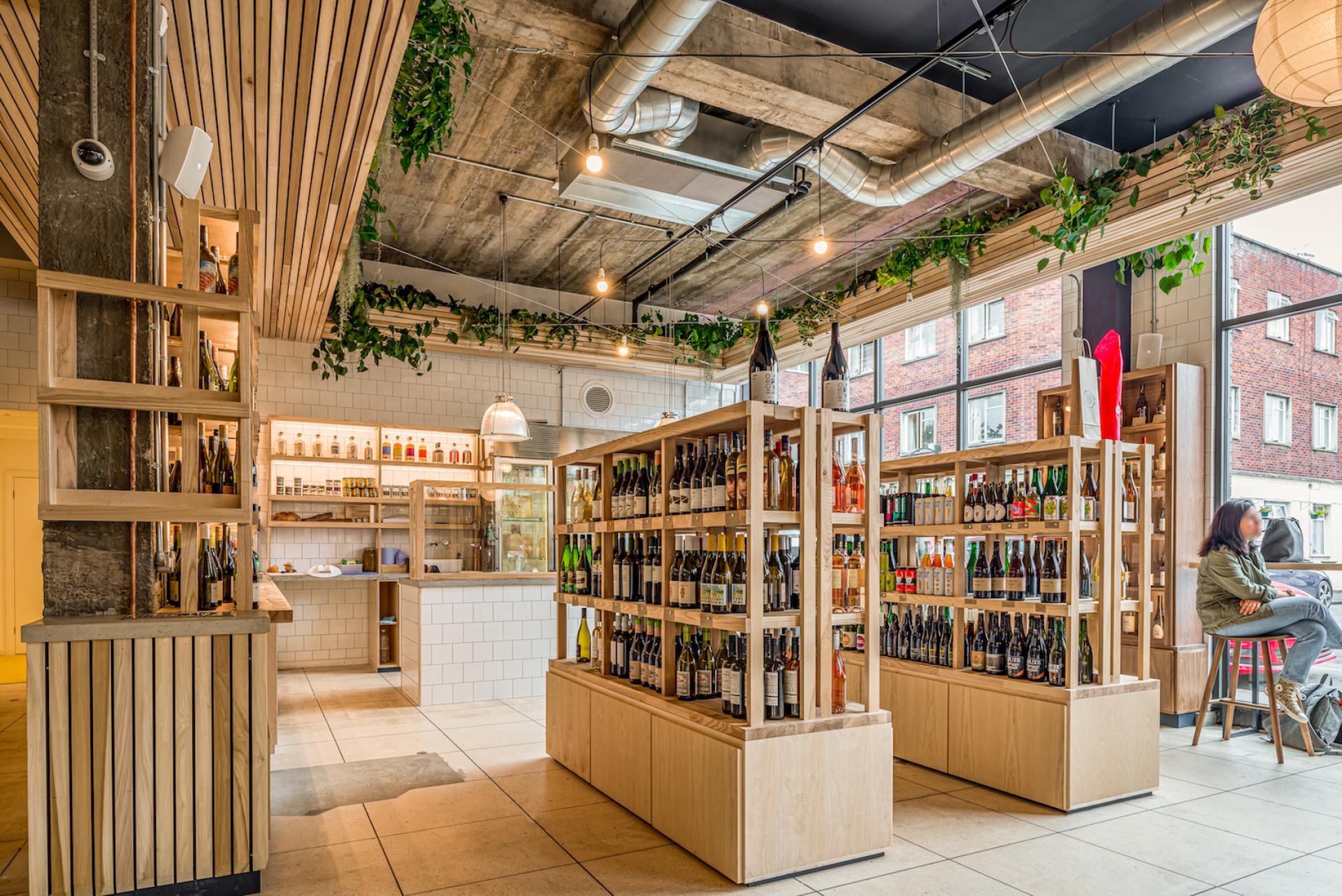 Brightly lit interior of The Bristol Loaf featuring wooden shelves filled with various beverages and a seating area.
