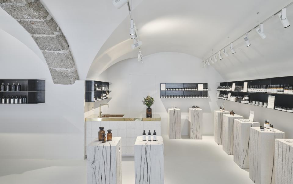 Bright, minimalist interior of Saint Charles natural cosmetics store in Salzburg, featuring wooden displays and a sleek counter.